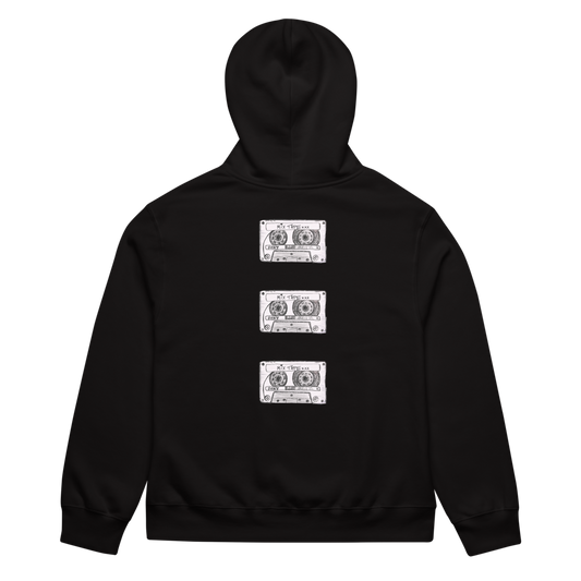 Flat lay image of the Mix Tape Oversized Hoody in black with cassette tape designs on the back against a plain background