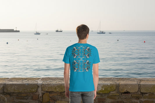 Man wearing a blue t-shirt with a squid design on the back, standing in a harbour looking out to sea.