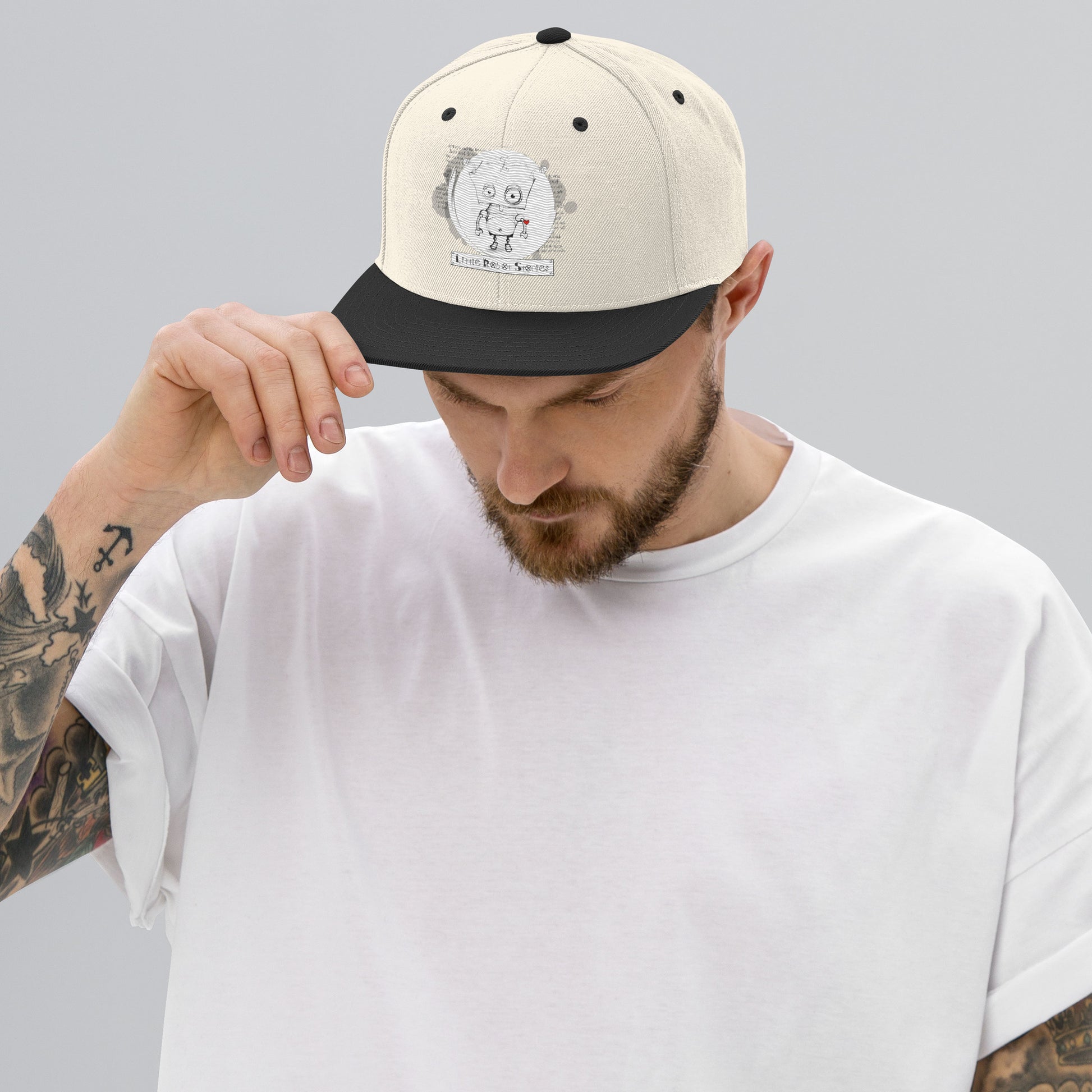 black and red Little Robot Stories snapback hat with children’s robot story art by Vicky Steane