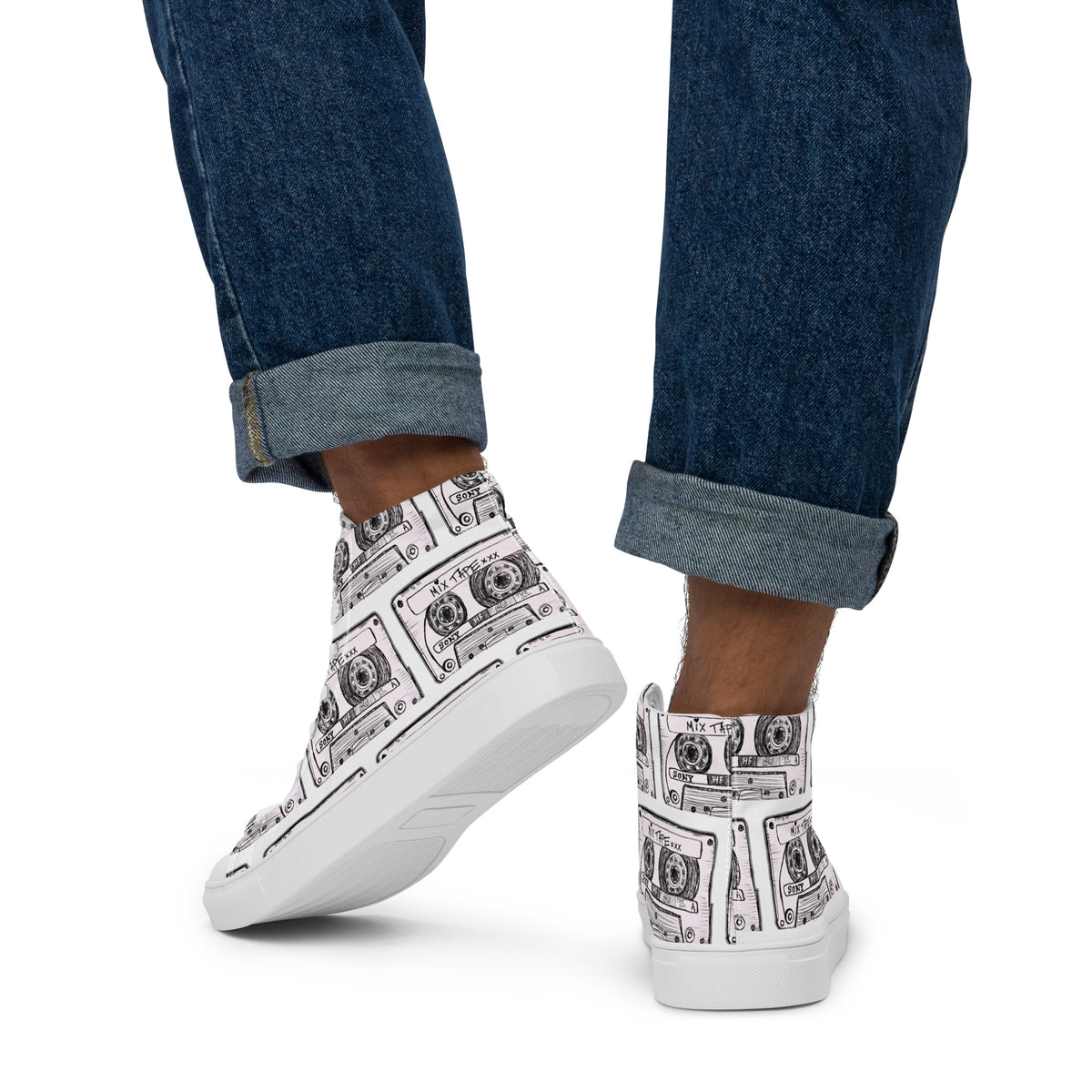  Vicky Steane's Mix Tape High Top Canvas Shoes with a black cassette tape  pattern, worn by a model in blue jeans against a white background.