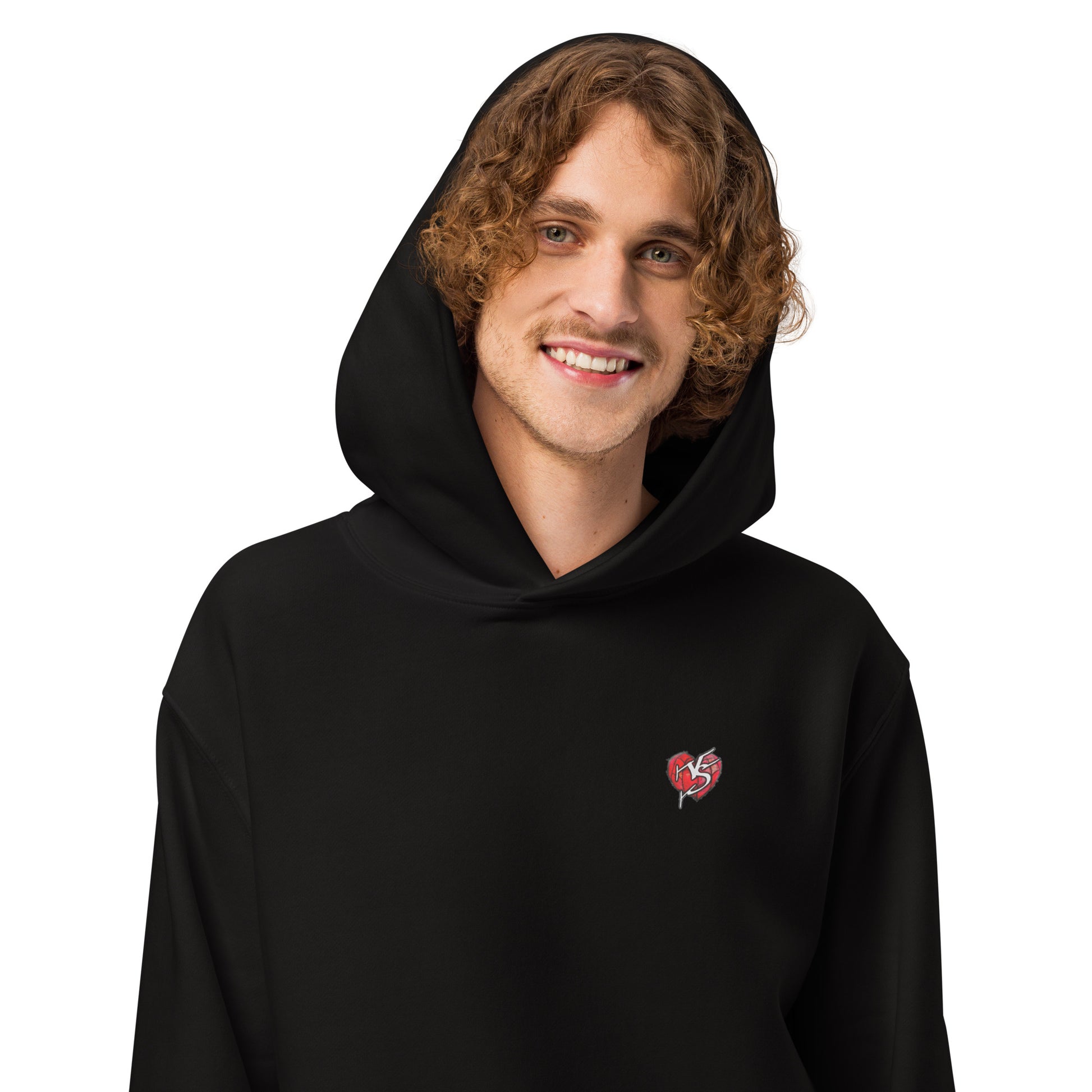 Close up of male model wearing Mix Tape Oversized Hoody in black, with the hood up, and a small Vicky Steane heart logo on a white background
