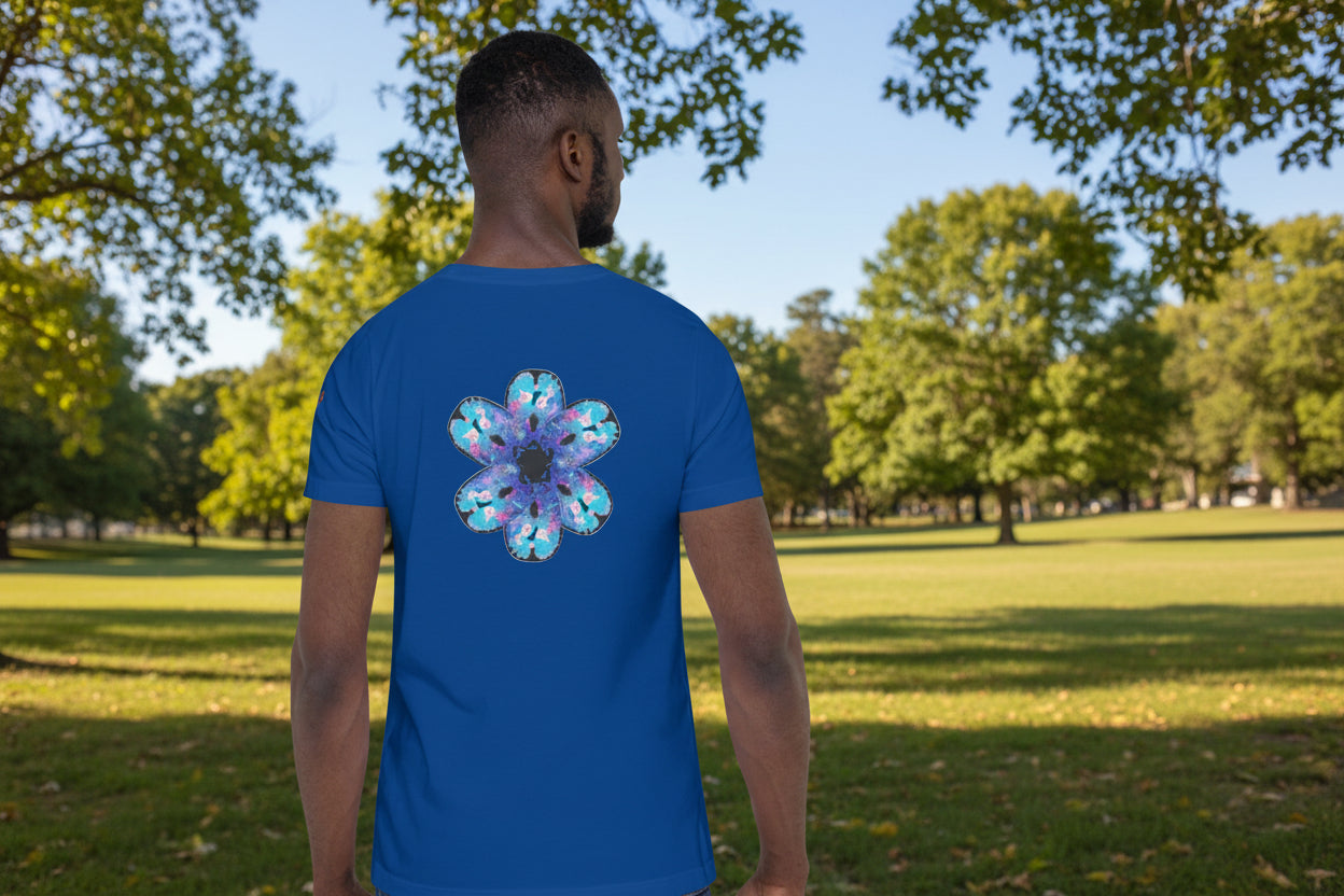 Man wearing a Pick Yourself Up blue t-shirt with a colorful brain scan  petals design on the back in a sunny park